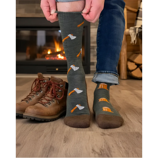 Dark gray merino wool socks with orange and white axe pattern worn with blue jeans perfect for hiking and trail use