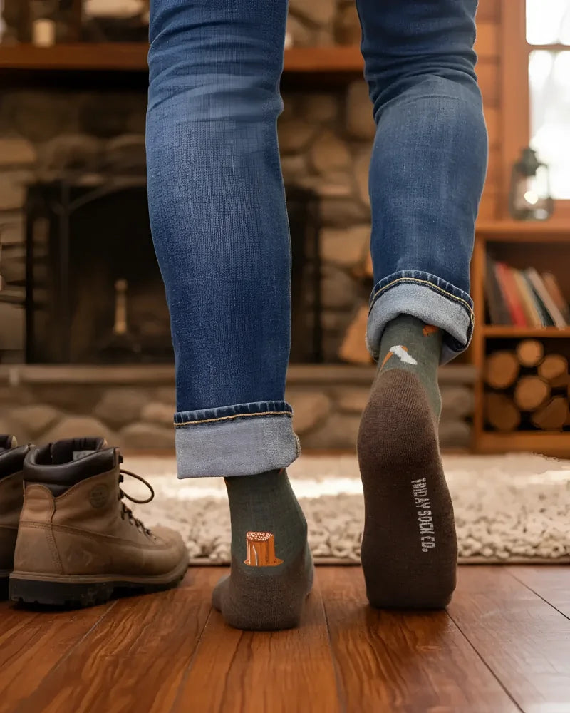 Dark olive green men’s merino wool socks with small orange tree stump and treasure sock co branding on heel for hiking
