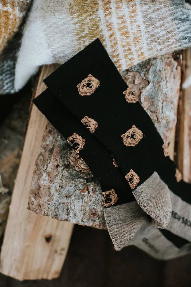 Men’s black merino wool socks with gold embroidered bear faces and gray ribbed cuffs for soft wool sock comfort