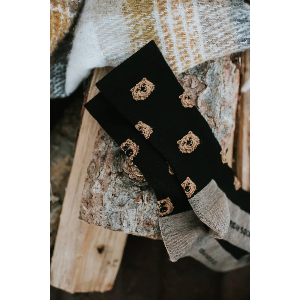 Men’s black merino wool socks with gold embroidered bear faces and gray ribbed cuffs for soft wool sock comfort