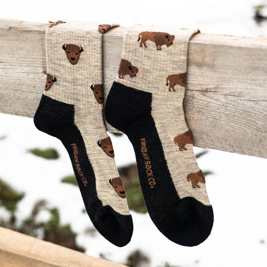 A pair of beige merino wool socks with brown bison prints and black toe and heel from friday sock co perfect for hiking