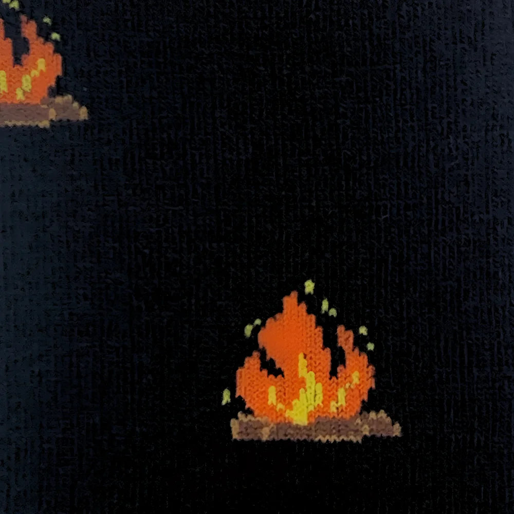 Black knit sweater with pixelated orange and yellow campfire designs pairs well with breathable merino wool socks