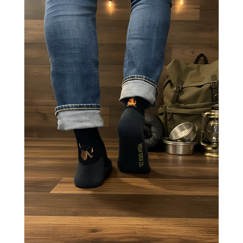 Men’s black merino wool socks with a brown orange campfire design and tawan socks co logo for camping at night
