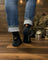 Men’s black merino wool socks with a brown orange campfire design and tawan socks co logo for camping at night