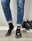 Men’s canada merino wool socks in black with red and white maple leaf designs and gray toe caps worn with cuffed jeans