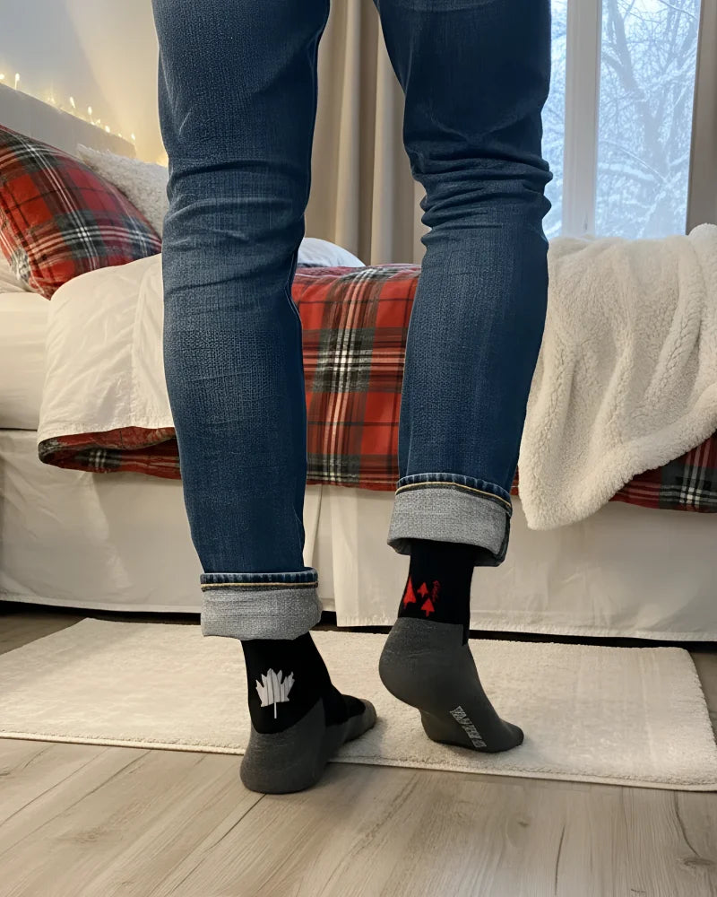Men’s canada merino wool socks featuring black wool socks with white maple leaf and red heel accents worn with blue jeans
