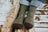 Men’s olive green merino wool socks with brown deer prints and dark brown toe caps worn with rolled-up jeans