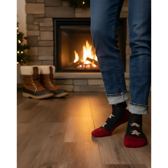 Men wearing black and red festive snowman merino wool socks with cuffed blue jeans for outdoor cozy warmth