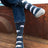 Men’s dark blue merino wool socks with white polar bear design and teal accents worn with rolled-up denim jeans