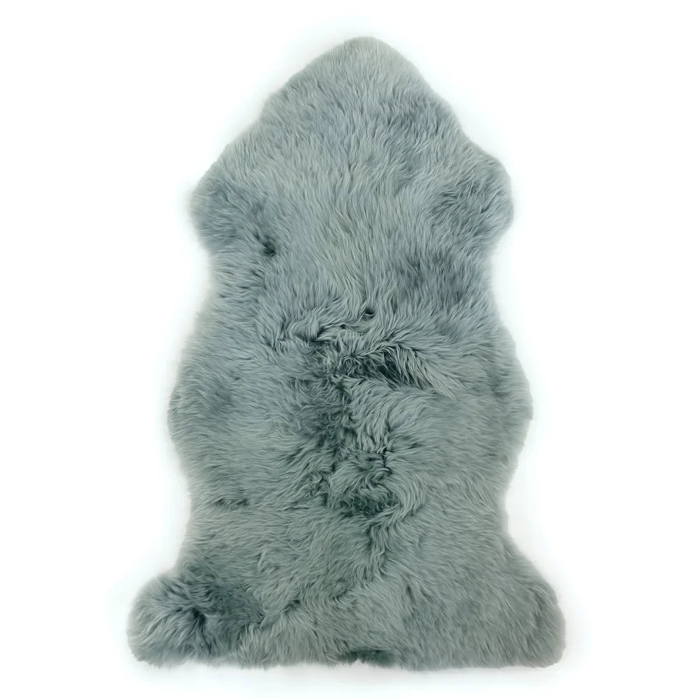A soft light gray dyed merino sheepskin rug with natural fluffy texture and irregular edges ideal for cozy decor
