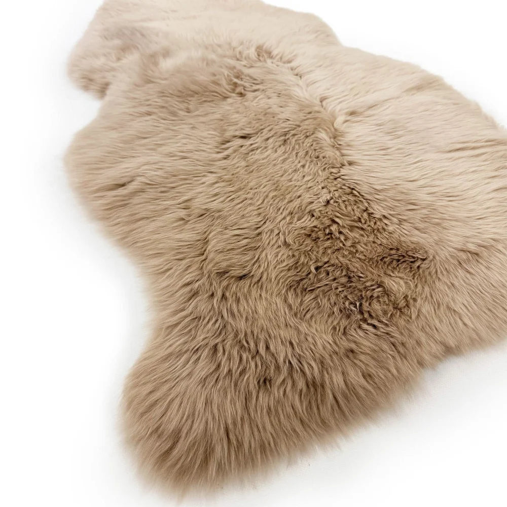 A soft beige dyed merino sheepskin rug with natural fluffy texture and irregular edges from merino sheepskins collection