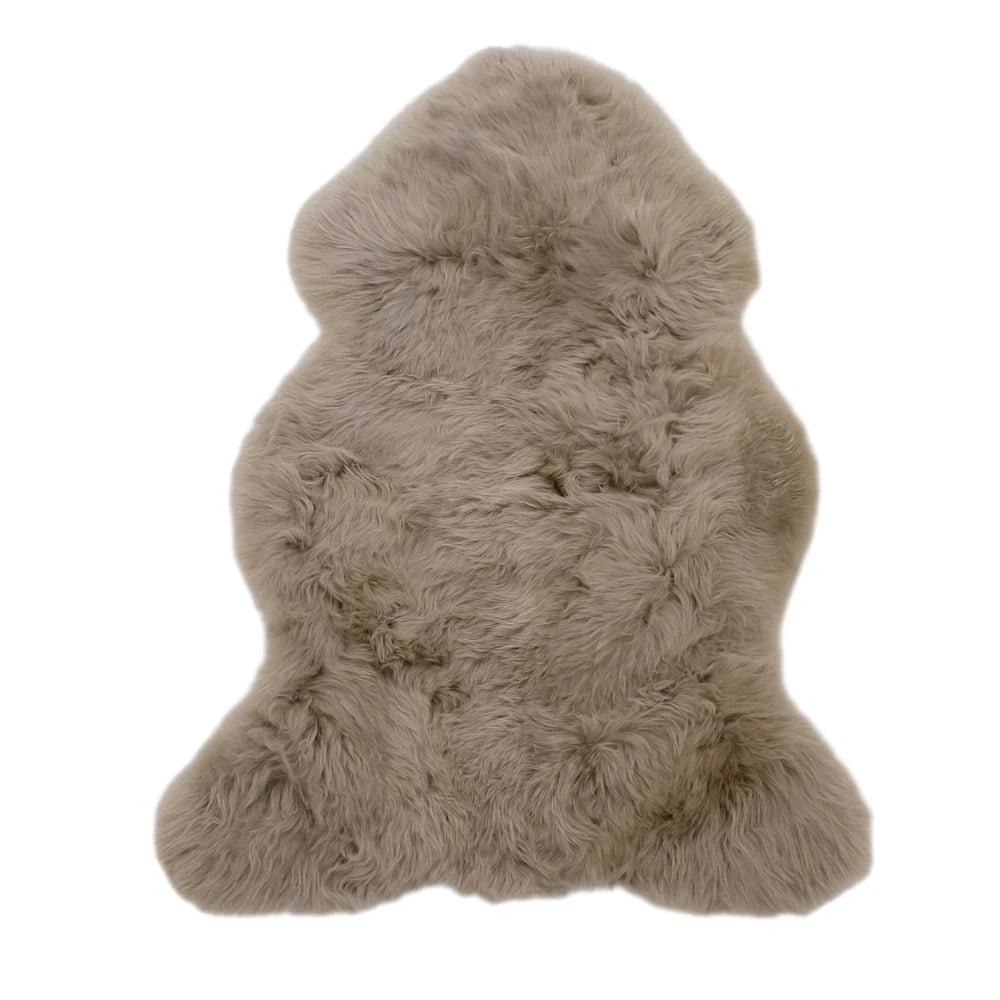 A soft light beige dyed merino sheepskin rug with natural fluffy texture and irregular edges