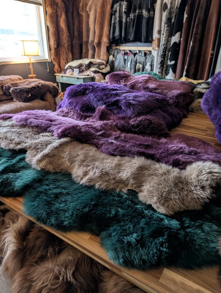 A plush multicolored merino sheepskin rug in purple teal and beige perfect for cozy home decor