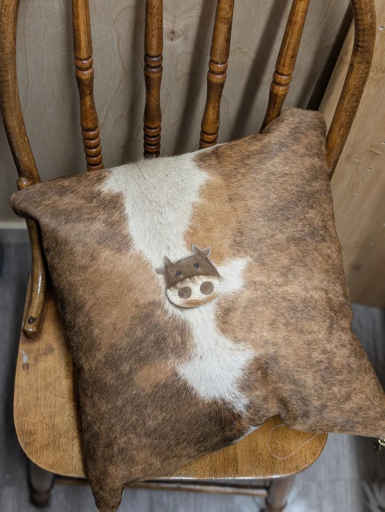 Brown and white mini moo double sided cowhide cushion with stitched on cow face design by angus oliver canada