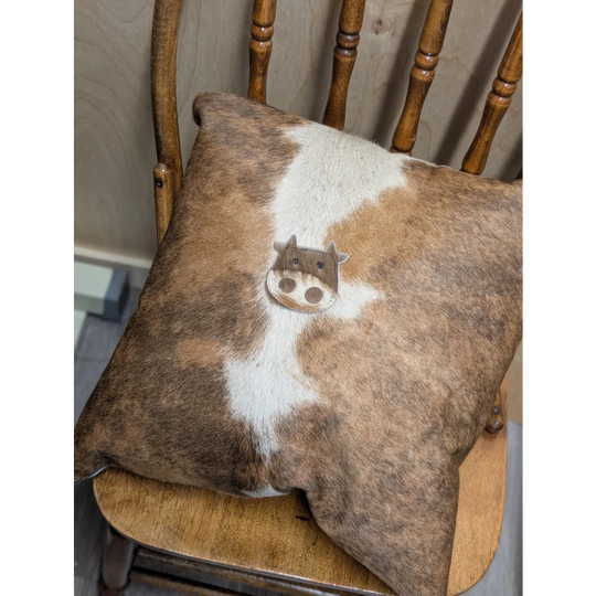 Brown and white mini moo double sided cowhide cushion with stitched cow face appliqué by angus oliver canada