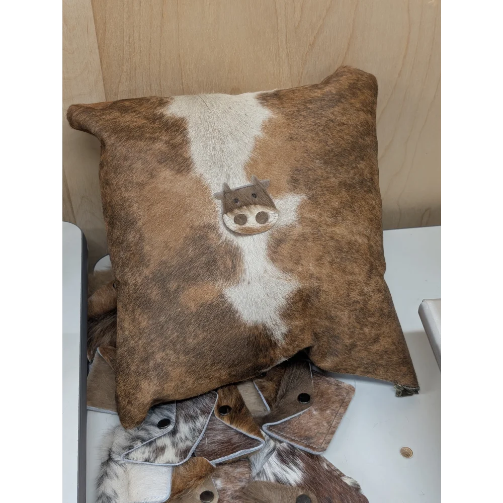 Brown and white cowhide mini moo cushion with stitched cow face design by angus oliver canada