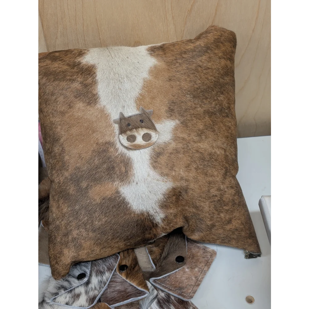 Brown and white cowhide mini moo cushion with stitched-on cow face design by angus oliver canada