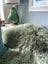 A plush, shaggy minty green merino sheepskin throw blanket with soft, curly texture arriving mid october