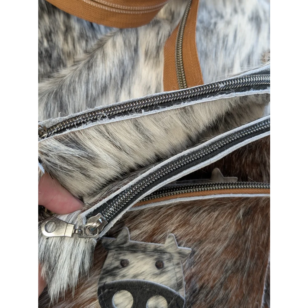 Moocoin purse by angus oliver canada featuring cow print faux fur, tan leather straps, and silver zippers coin purse