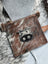 Brown and white cowhide coin purse with black stitched cow face appliqué from angus oliver canada