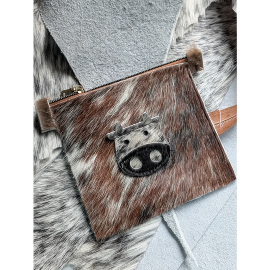 Brown and white cowhide coin purse with black stitched cow face appliqué from angus oliver canada