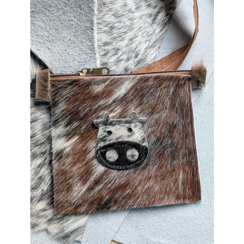 Brown and white cowhide coin purse with black stitched cow face appliqué by angus oliver canada