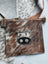 Brown and white cowhide coin purse with black stitched cow face appliqué by angus oliver canada