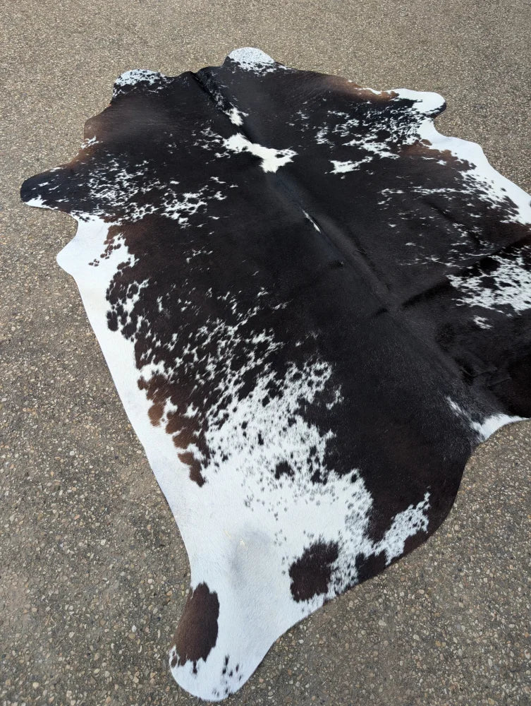 A natural black and white large cowhide rug with unique speckled pattern perfect for beautiful rugs collections