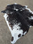 A natural black and white large cowhide rug with unique speckled pattern perfect for beautiful rugs collections