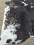 Large cowhide rug with beautiful black white and natural brown patches showcasing unique characteristics