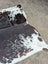 A large cowhide rug with natural brown and white spots showcasing unique characteristics for beautiful rugs