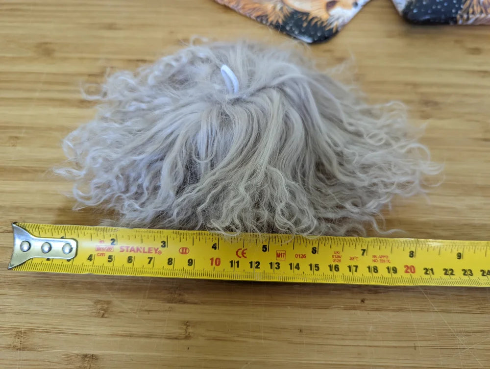 Gray fluffy mushroom sheepskin pom yarn ball with yellow tape