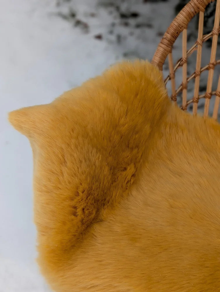 A plush cat-shaped pillow made of mustard yellow merino sheepskin with soft fluffy texture and pointed ears