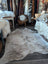 A natural, full-sized cowhide rug with a mottled pattern of white and brown fur.