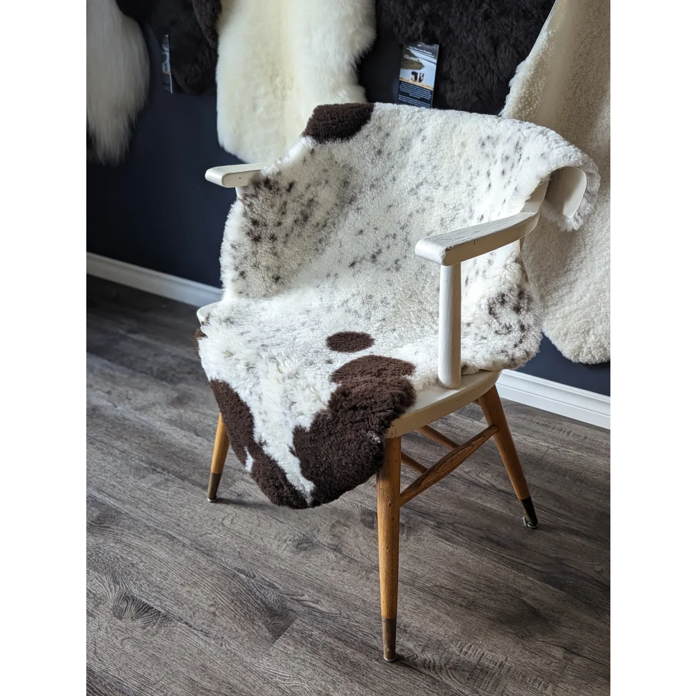 Gorgeous merino sheepskin cowhide chair cover with brown white spots, wooden legs