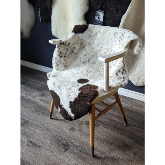 Gorgeous merino sheepskin cowhide chair cover with brown white spots, wooden legs