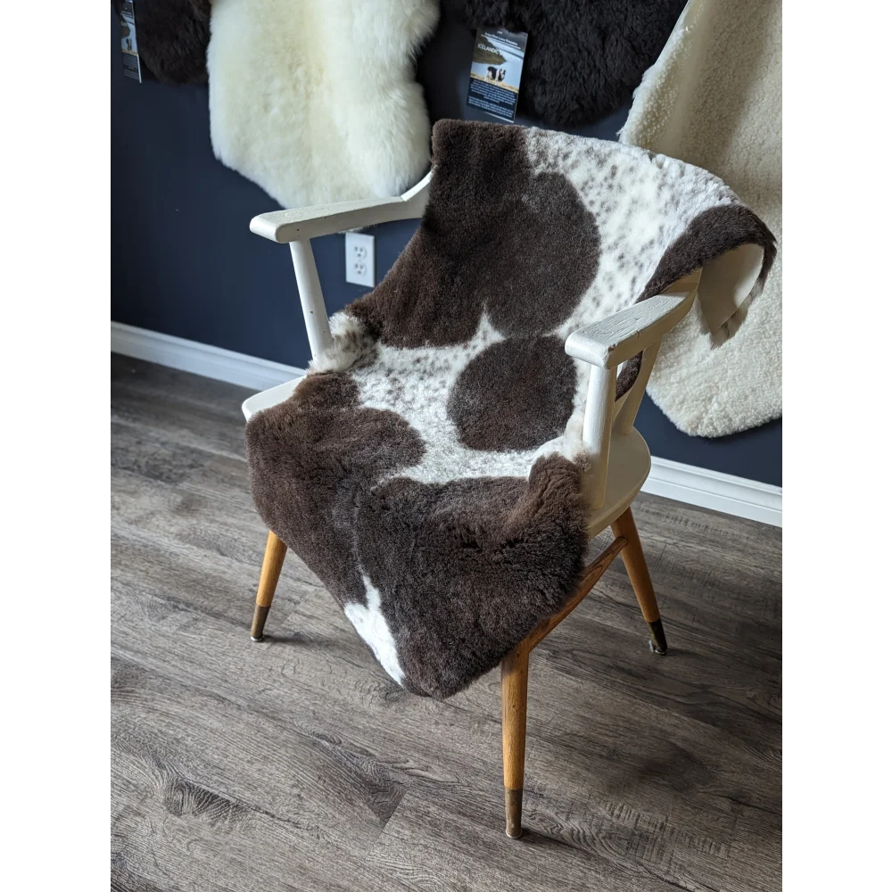 Gorgeous merino sheepskin cowhide chair cover with brown white spots, wooden legs