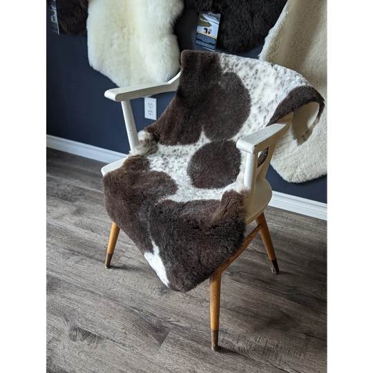Gorgeous merino sheepskin cowhide chair cover with brown white spots, wooden legs