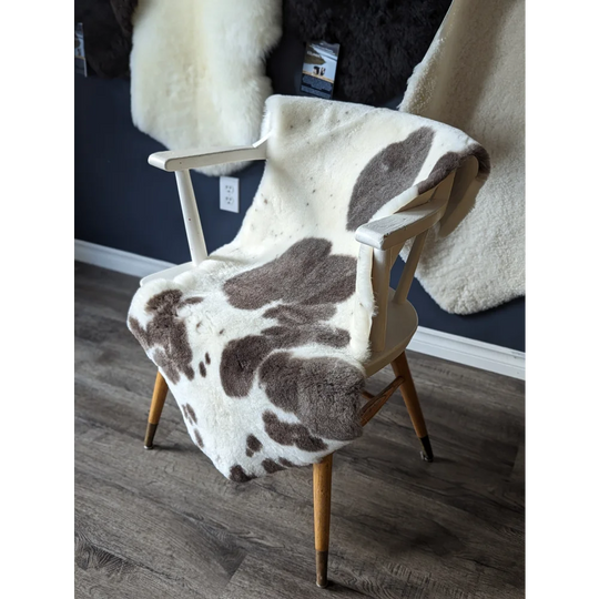 Gorgeous merino sheepskin cow print throw blanket with faux fur backrest