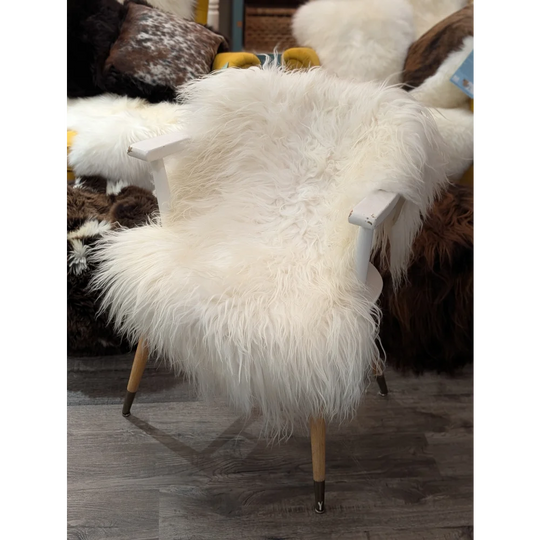 Natural white Icelandic sheepskin chair with fluffy sheepskin rug cover and wooden legs with metal tips