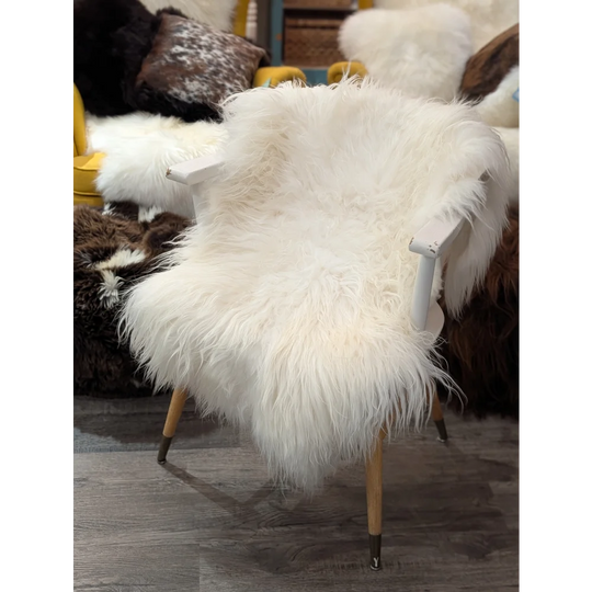 Natural white icelandic sheepskin fluffy chair with wooden legs and white painted armrests perfect for cozy spaces
