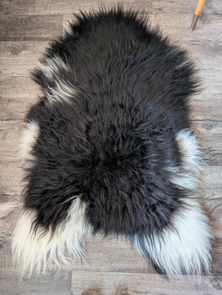 A plush natural black icelandic sheepskin rug with long soft fur perfect for cozy home decor