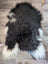 A plush natural black icelandic sheepskin rug with long soft fur perfect for cozy home decor