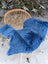 Vibrant blue merino sheepskin faux fur throw blanket draped over wicker chair perfect for mid october cozy vibes