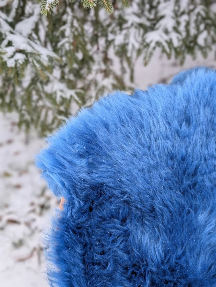 A plush navy blue merino sheepskin blanket with vibrant faux fur texture perfect for cozy mid october nights