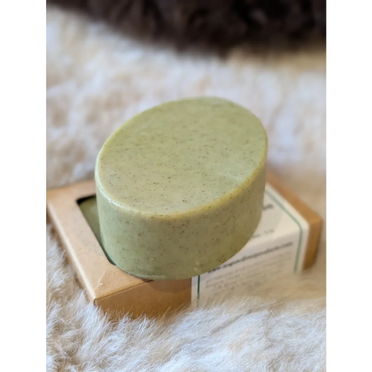 Green speckled nettle and tea tree soap bar on wooden stand