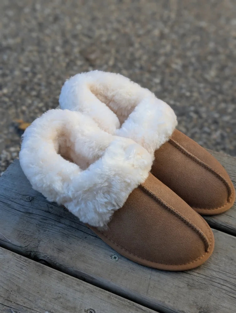 Tan suede slip-on sheepskin slippers with plush white shearling lining the ultimate sheepskin cozy choice