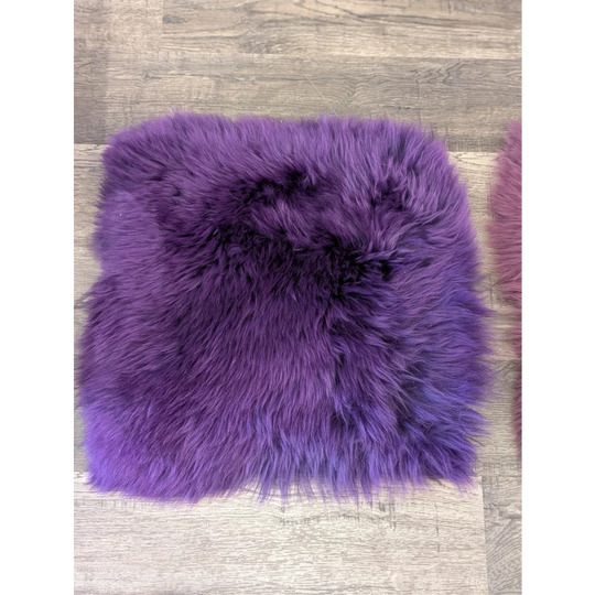 A plush purple sheepskin pet square cushion with soft fluffy texture fits perfectly in ikea storage units like kallax