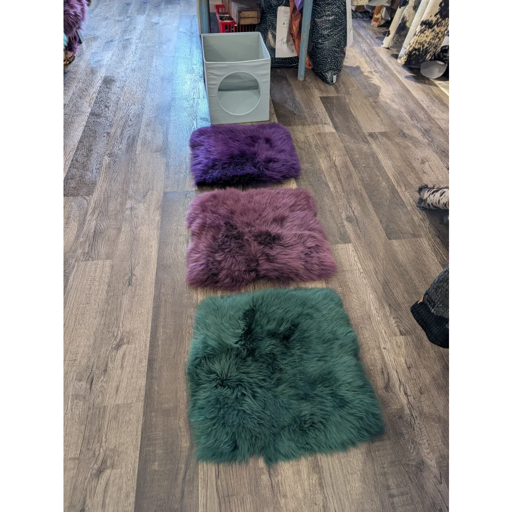 Three plush sheepskin squares in purple mauve and green fit perfectly on ikea storage units for pets