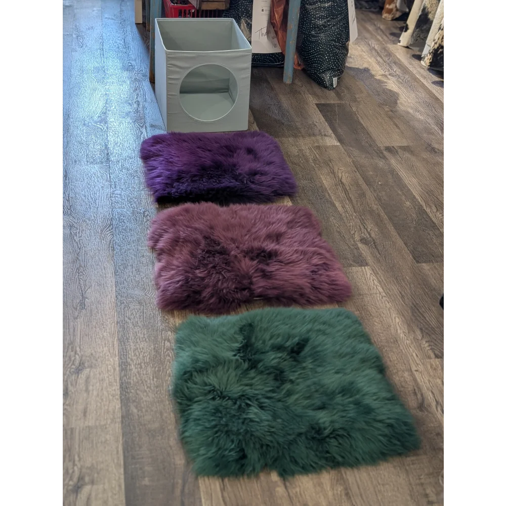 Three plush sheepskin squares in purple dusty rose and green fit perfectly in ikea storage units like kallax cat boxes